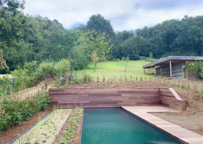 ecozwembad met plantenfilter gebouwd in sterk hellende tuin