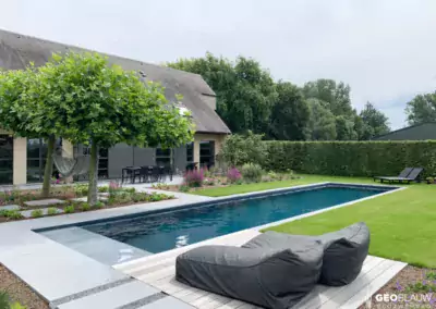 Hybride zwembad in ruime tuin met bomen en hangmat