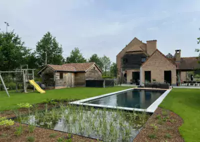 Natuurlijk zwembad met plantenzone en terras in landelijke tuin