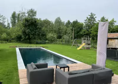 natuurlijk zwembad met plantenfilter en houten terras met lounge
