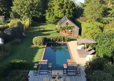 poolparty in tuin met natuurlijk zwembad en kiezelstrand