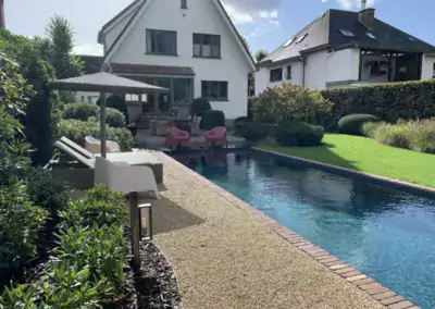 terras en tuin met natuurlijk zwembad en kiezelstrand