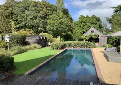tuin met natuurlijk zwembad en kiezelstrand